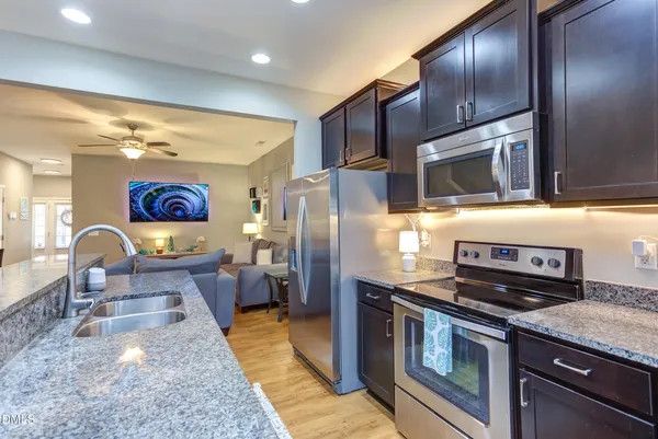 a kitchen with stainless steel appliances granite countertop a stove a sink dishwasher a microwave oven with granite countertops and cabinets