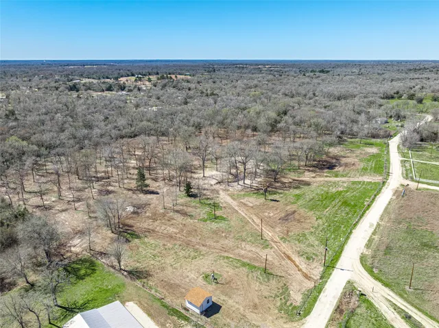 a view of a dry yard with wooden fence