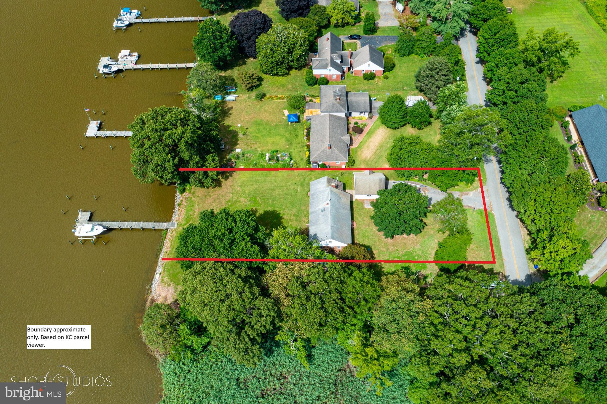 an aerial view of residential house with outdoor space and trees all around