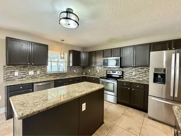 a kitchen with granite countertop stainless steel appliances and wooden cabinets