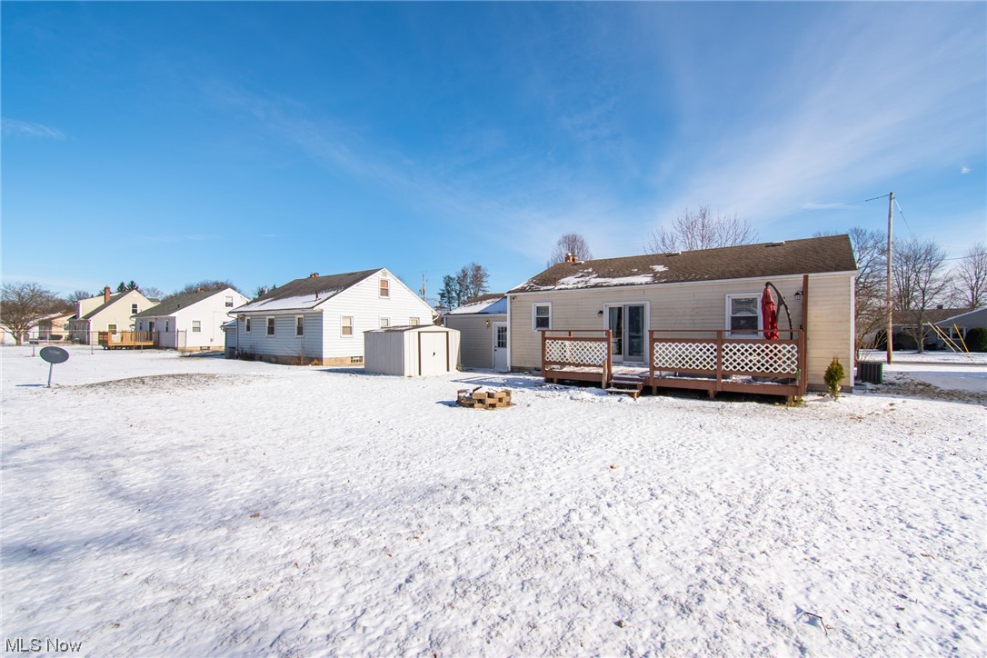 2926 Brunswick Road Youngstown, OH 44511 - Photo 29 of 33 Rear of house with a storage unit, a deck, fir pit, garage man door and central AC