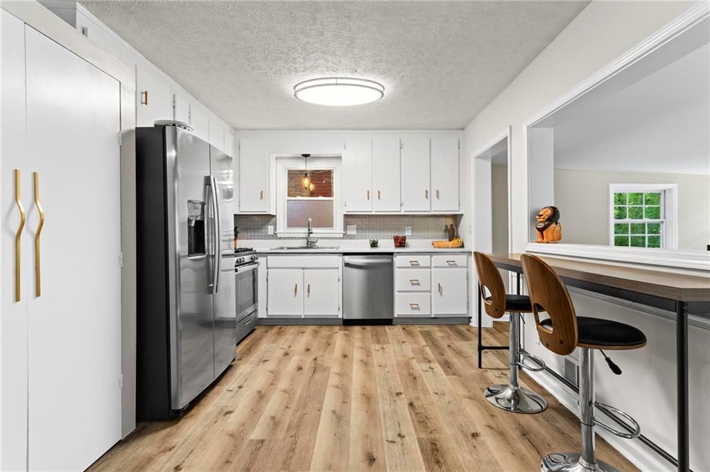6971 Recreation Lane Acworth, GA 30102 - Photo 8 of 23 a kitchen with a sink a counter top space stainless steel appliances and cabinets