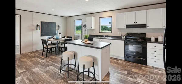 a kitchen with stainless steel appliances granite countertop a stove top oven a sink a counter space and cabinets