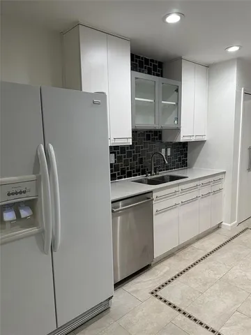 a kitchen with stainless steel appliances granite countertop a refrigerator sink and cabinets
