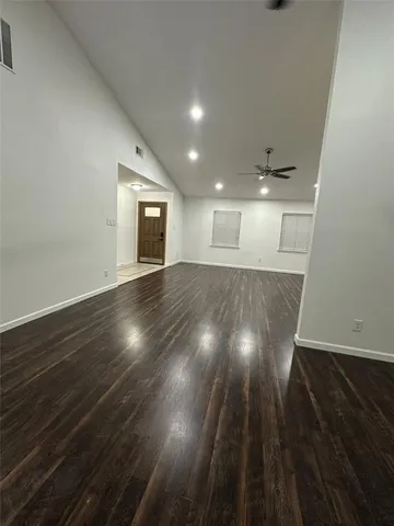 a view of an empty room with wooden floor