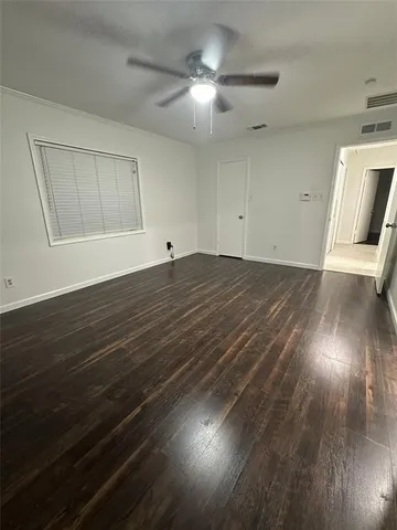 a view of a livingroom with wooden floor and a ceiling fan