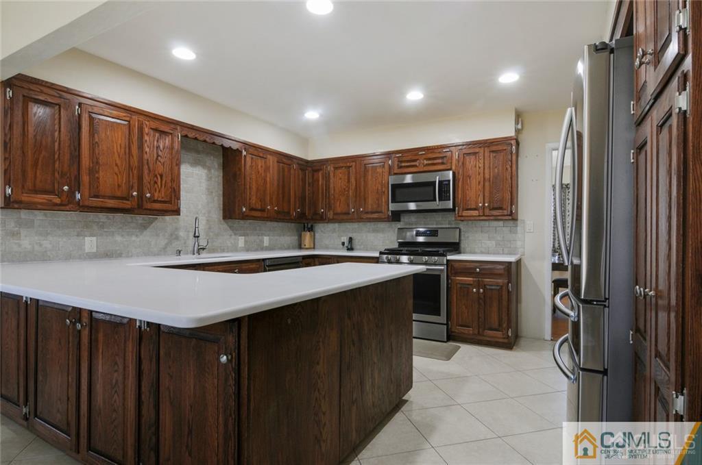 62 Gage Road East Brunswick, NJ 08816 - Photo 3 of 23 a kitchen with stainless steel appliances granite countertop a refrigerator stove a sink and a microwave oven