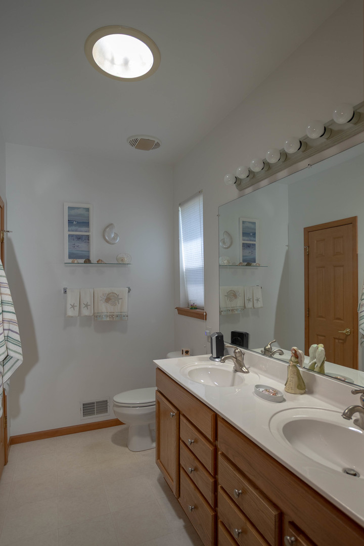 212 Rodeo Drive, Unit 2179 Grayslake, IL 60030 - Photo 29 of 31 a bathroom with a double vanity sink and a mirror