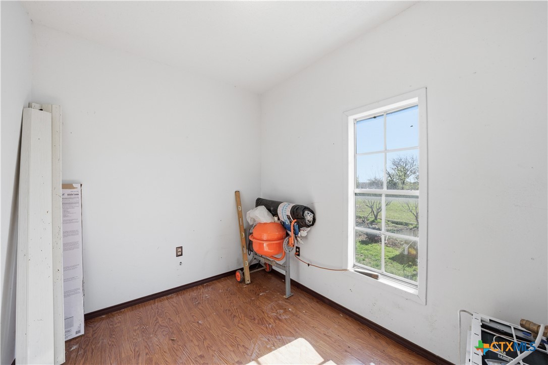 1780 Moores Mill Road Temple, TX 76504 - Photo 11 of 17 wooden floor in an empty room with a window