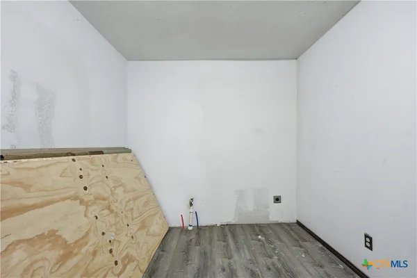 a view of an empty room and wooden floor