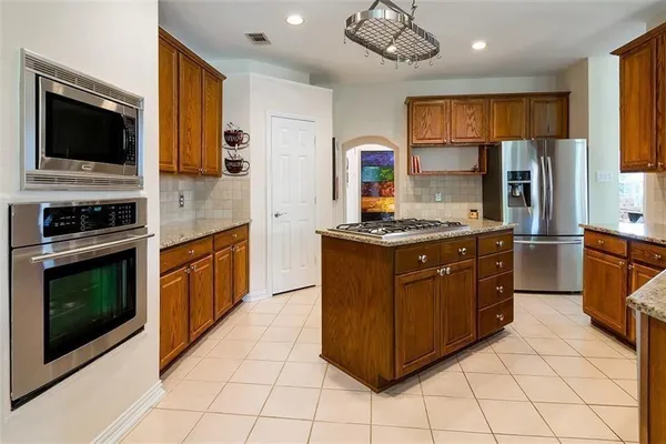 a kitchen with stainless steel appliances granite countertop a stove microwave and refrigerator