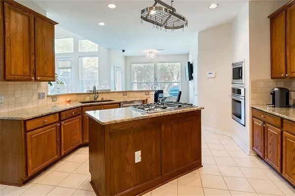 a kitchen with stainless steel appliances granite countertop a sink counter space cabinets and a large window