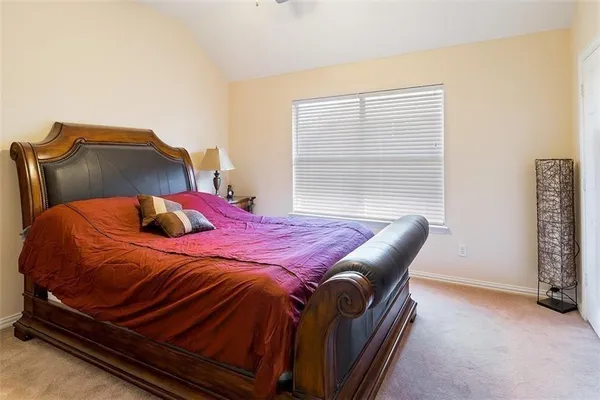a bed sitting in a bedroom next to a window