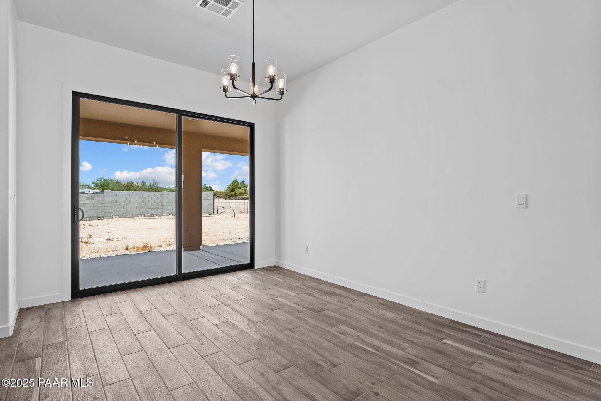 21032 West Skinner Road Wittmann, AZ 85361 - Photo 12 of 34 a view of an empty room with wooden floor and a window