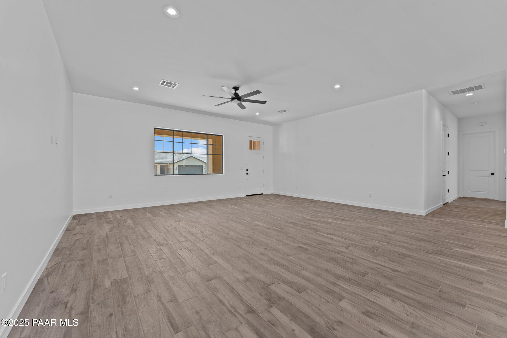 21032 West Skinner Road Wittmann, AZ 85361 - Photo 17 of 34 an empty room with wooden floor and windows