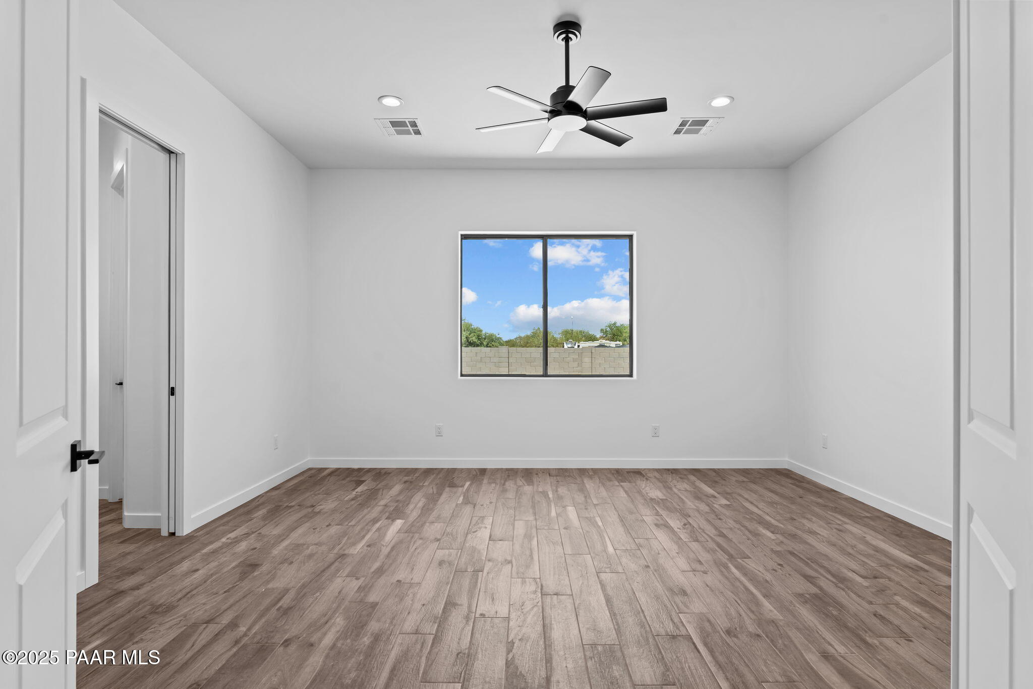 21032 West Skinner Road Wittmann, AZ 85361 - Photo 18 of 34 a view of empty room with wooden floor and fan