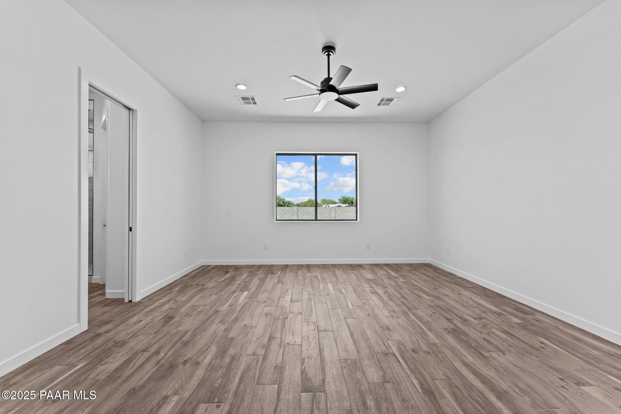 21032 West Skinner Road Wittmann, AZ 85361 - Photo 19 of 34 wooden floor in an empty room with a window