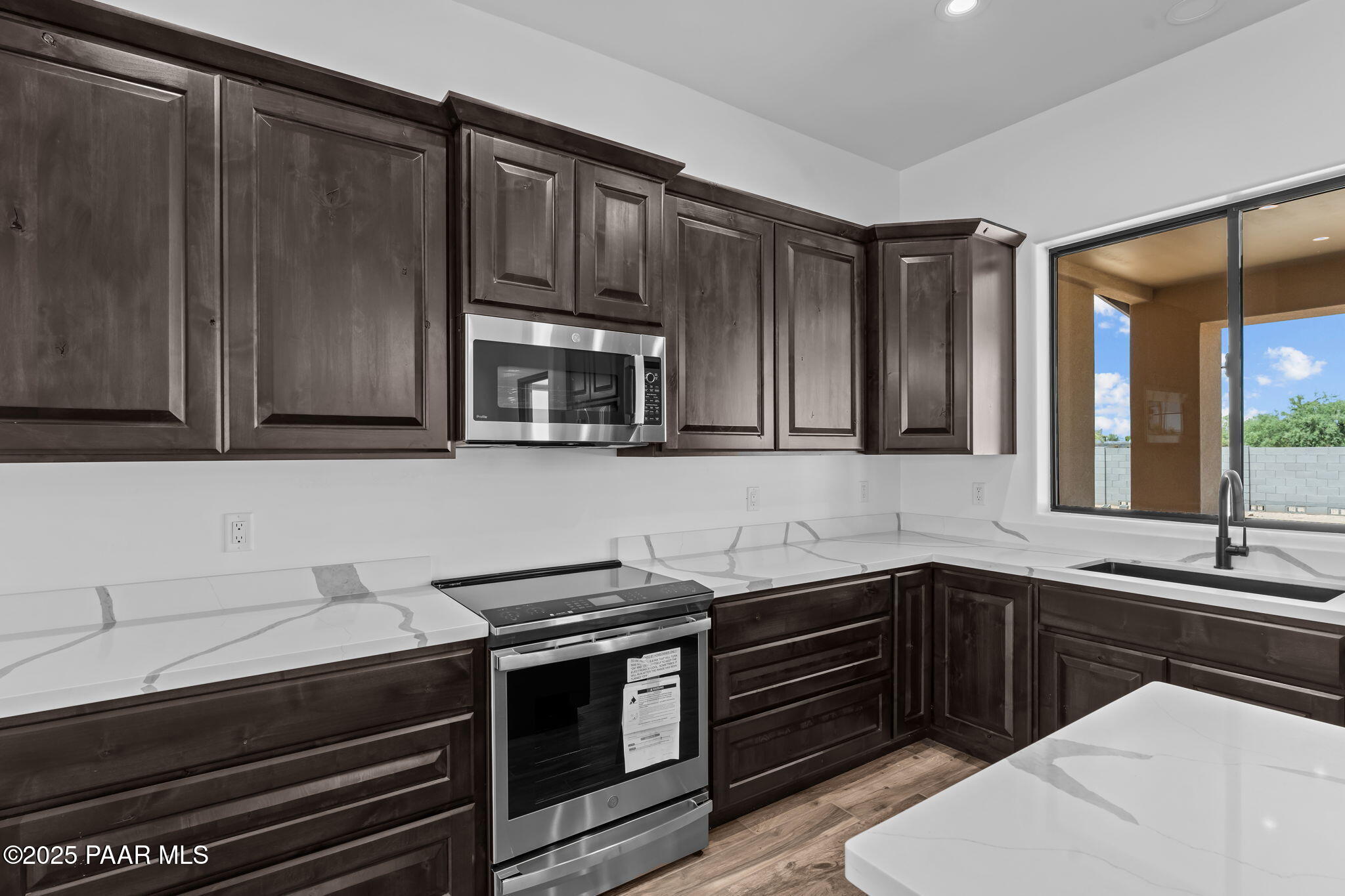 21032 West Skinner Road Wittmann, AZ 85361 - Photo 8 of 34 a kitchen with stainless steel appliances a sink stove and cabinets