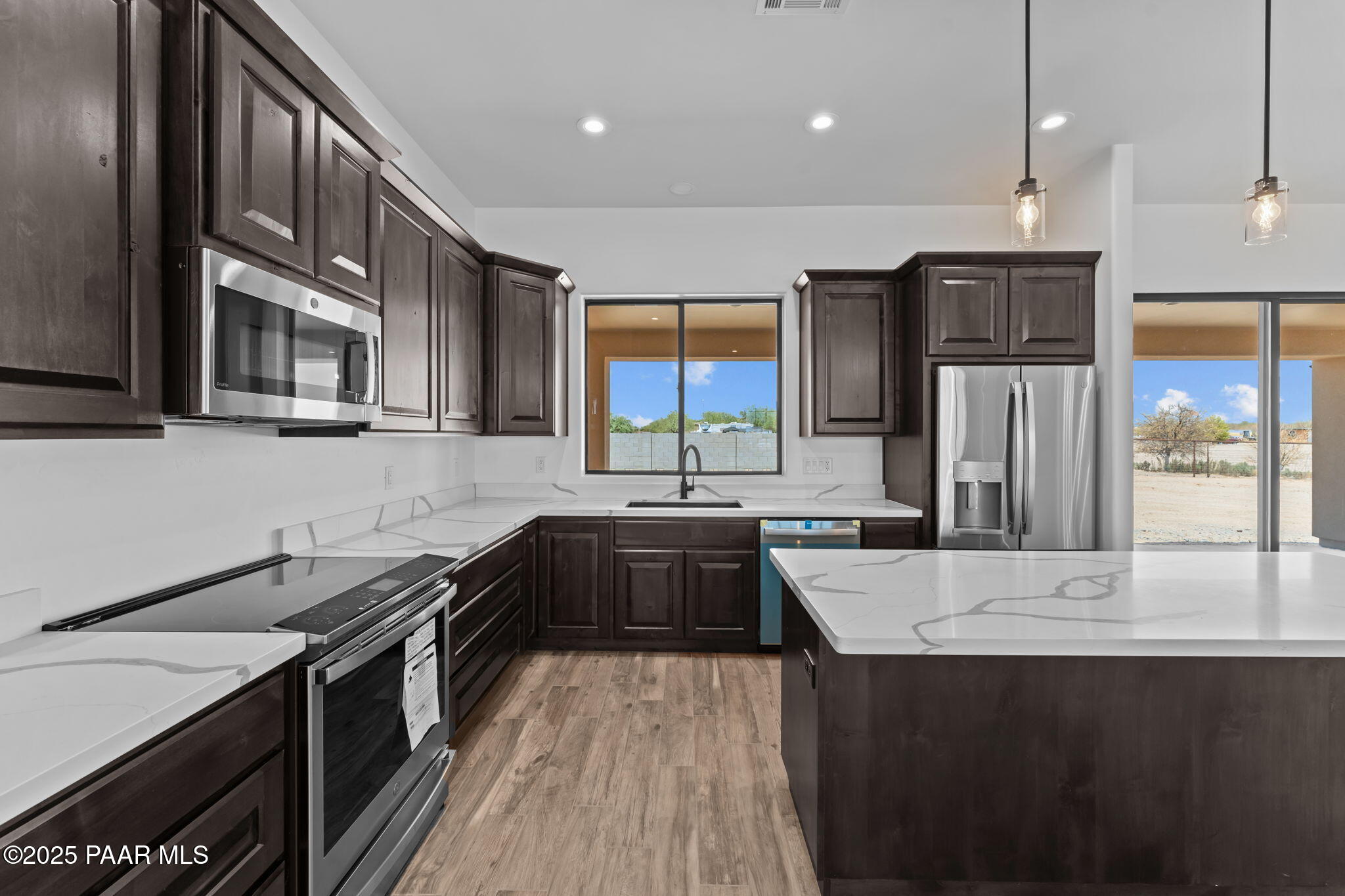 21032 West Skinner Road Wittmann, AZ 85361 - Photo 9 of 34 a kitchen with stainless steel appliances granite countertop a sink a stove and a refrigerator