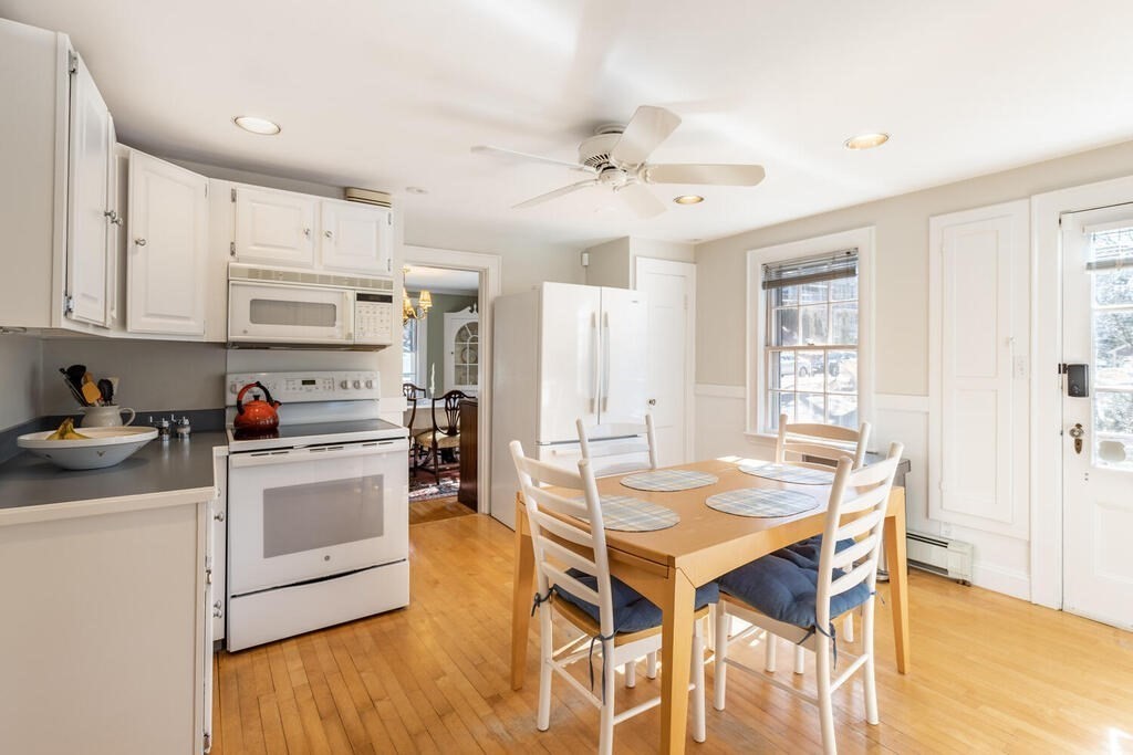 64 Wachusett Road Needham, MA 02492 - Photo 8 of 25 a kitchen with stainless steel appliances a white table chairs and a refrigerator