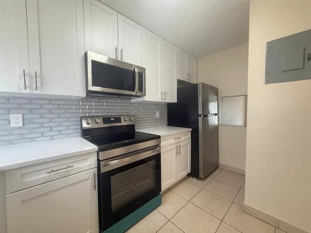 a kitchen with stainless steel appliances a stove microwave and refrigerator