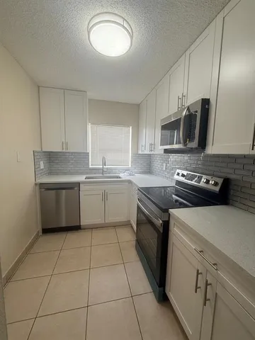 a kitchen with a sink a stove and cabinets