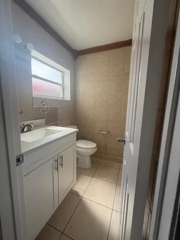 a bathroom with a double vanity sink toilet and a mirror