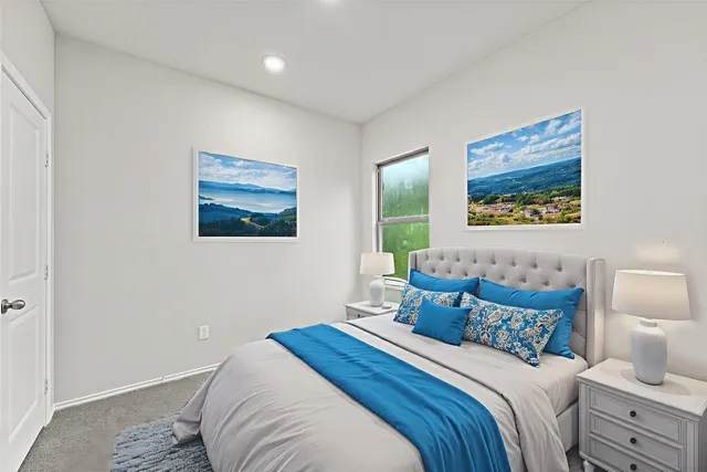 a bedroom with bed and a painting on the wall