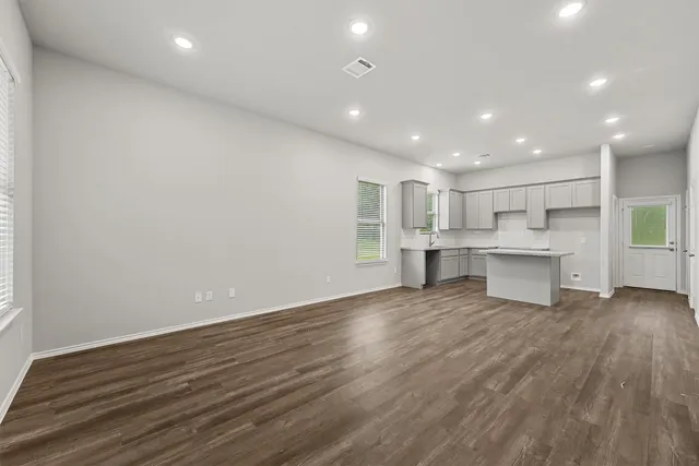 a view of a kitchen with a sink and dishwasher a refrigerator with wooden floor