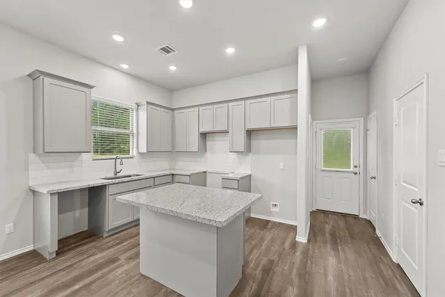 a kitchen with a sink stove and cabinets
