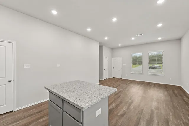 an empty room with wooden floor and window