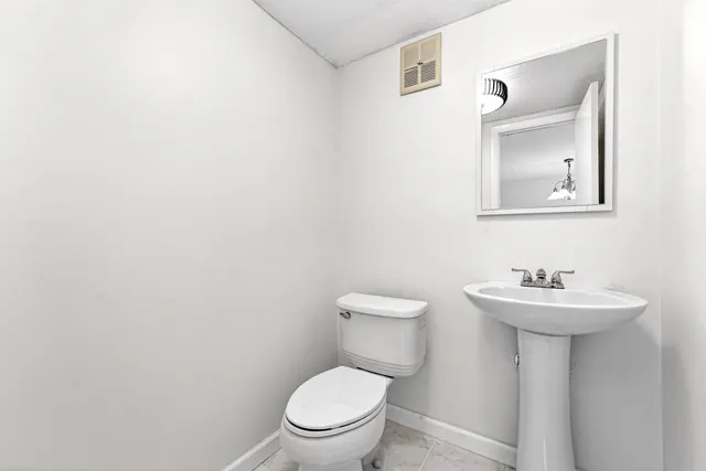 a bathroom with a sink a toilet and mirror