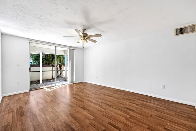 a view of an empty room with glass door and balcony