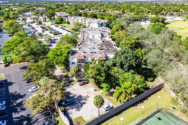 an aerial view of residential house with outdoor space and trees all around