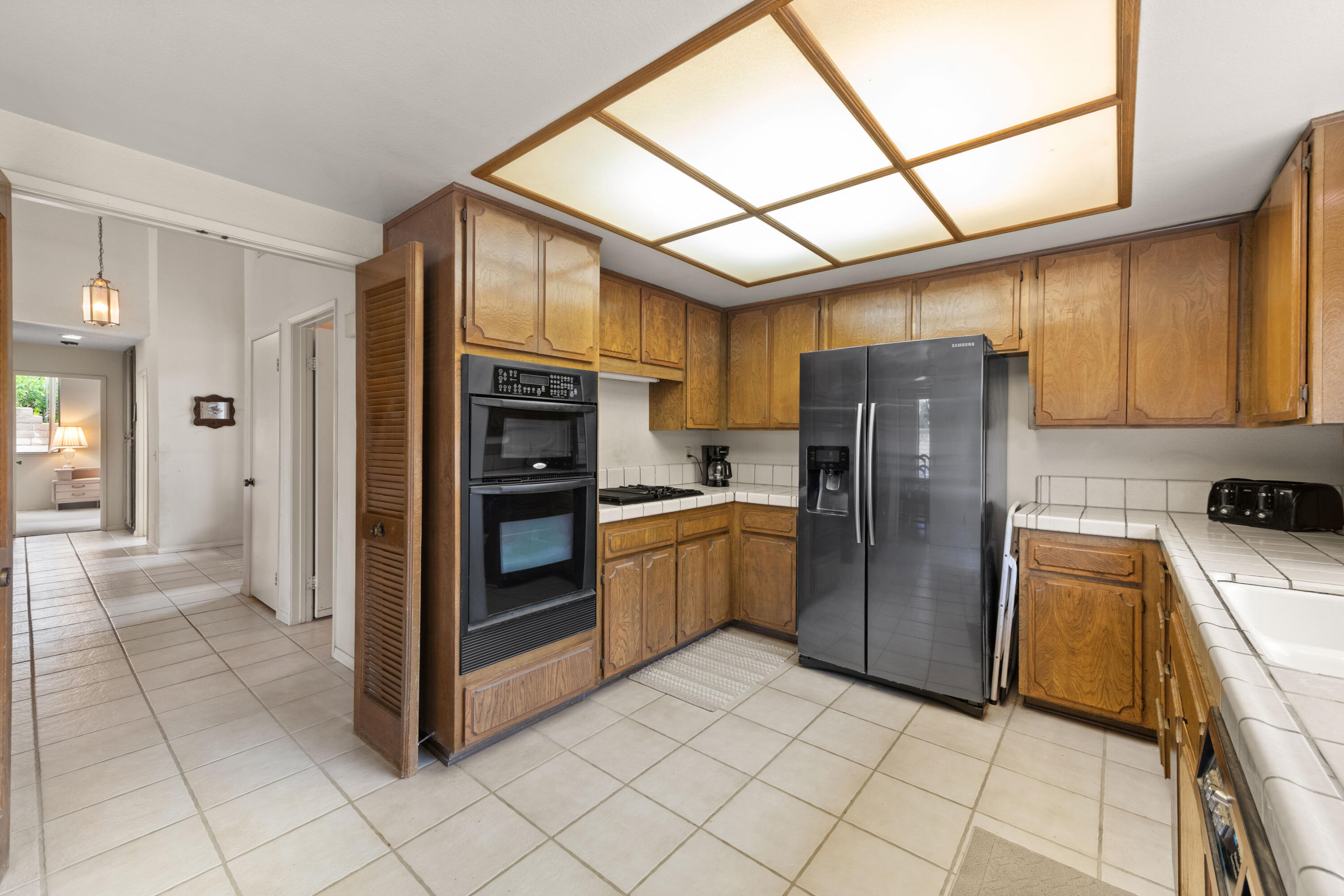 53 San Simeon Place Rancho Mirage, CA 92270 - Photo 11 of 30 a kitchen with a refrigerator and a sink