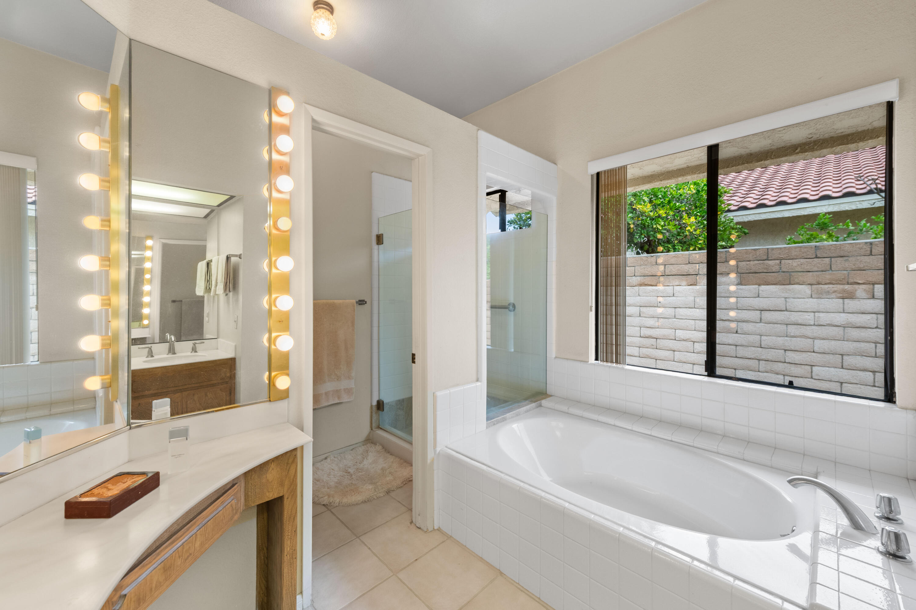 53 San Simeon Place Rancho Mirage, CA 92270 - Photo 17 of 30 a bathroom with a granite countertop tub sink and mirror