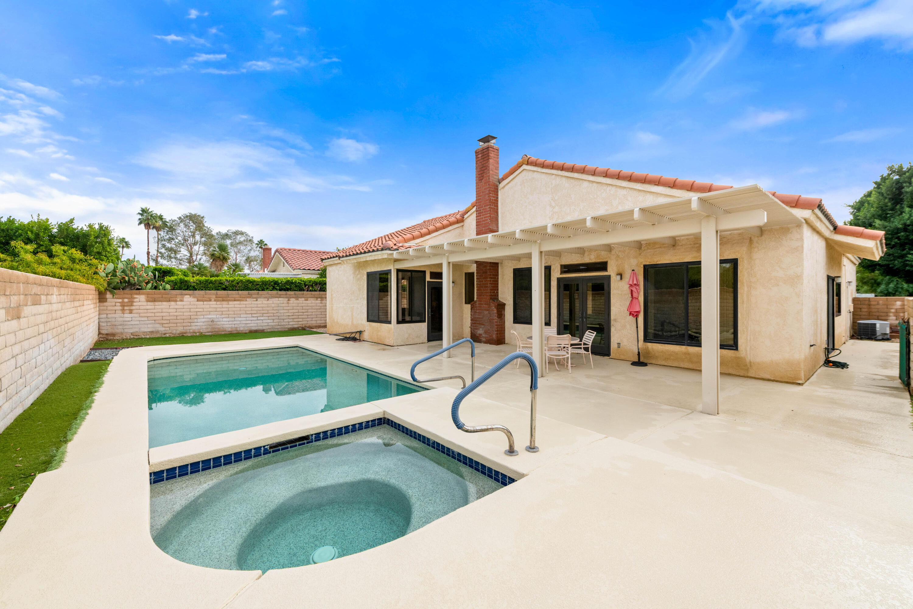 53 San Simeon Place Rancho Mirage, CA 92270 - Photo 24 of 30 a view of a white house with a swimming pool and sitting area