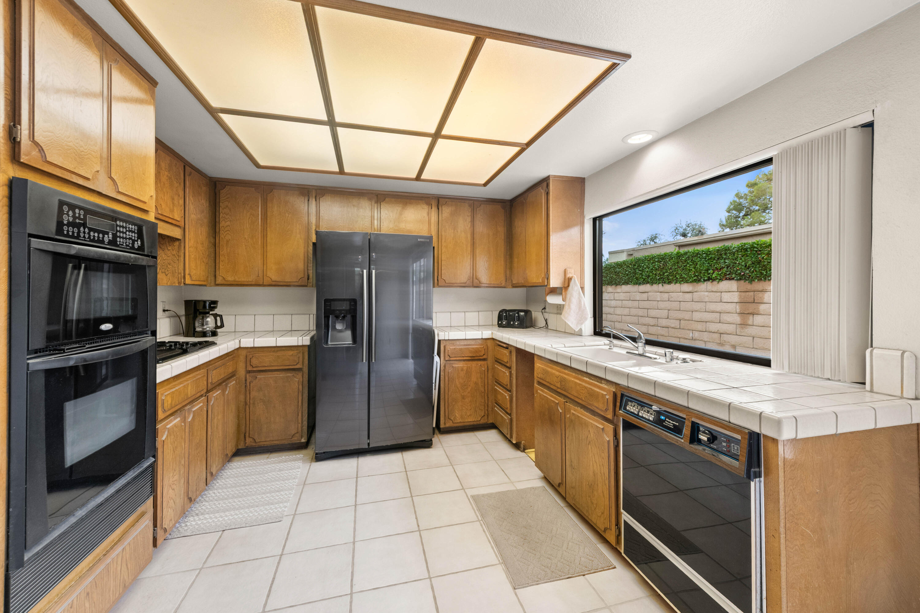 53 San Simeon Place Rancho Mirage, CA 92270 - Photo 10 of 30 a kitchen with stainless steel appliances granite countertop a stove a sink and a microwave