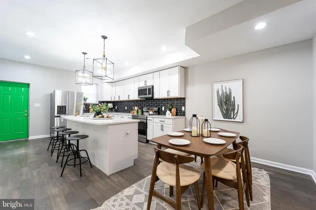 a kitchen with a dining table chairs stainless steel appliances and cabinets
