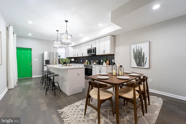 a kitchen with a dining table chairs and microwave