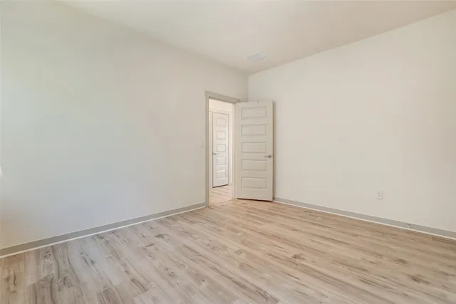 an empty room with a hardwood and a window