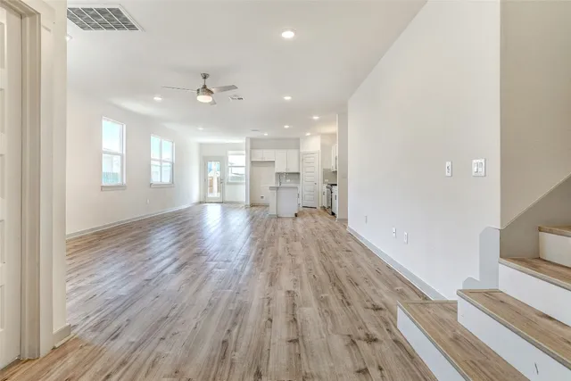 a view of a kitchen with wooden floor and a kitchen island