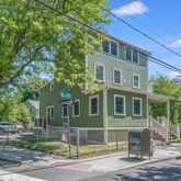 a front view of a house with a tree