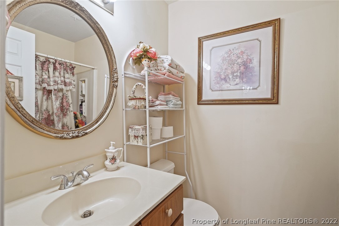 4372 Bona Court Raleigh, NC 27604 - Photo 26 of 41 a bathroom with a toilet a sink and a mirror