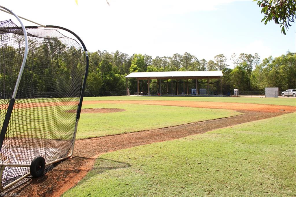 a view of a swimming pool with a yard and large trees