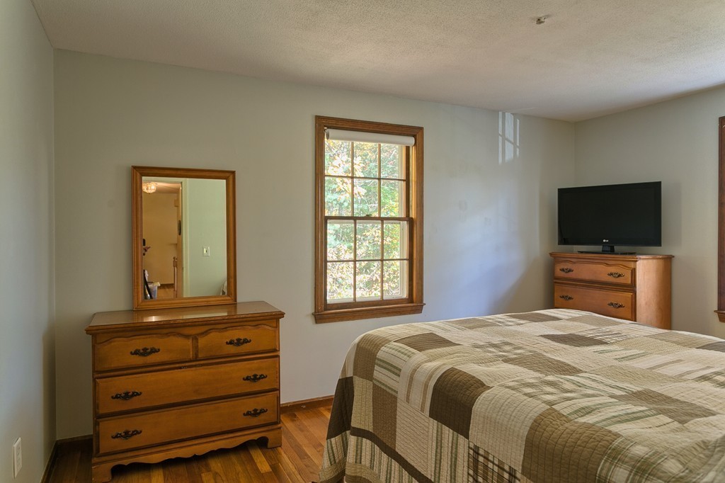 597 Old Dunstable Road Groton, MA 01450 - Photo 16 of 21 a bedroom with a bed and a flat screen tv