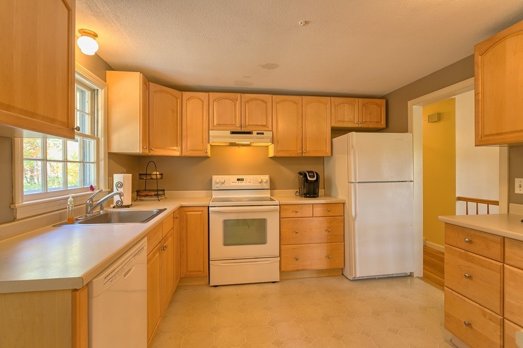 597 Old Dunstable Road Groton, MA 01450 - Photo 9 of 21 a kitchen with a refrigerator a stove a sink cabinets and a window