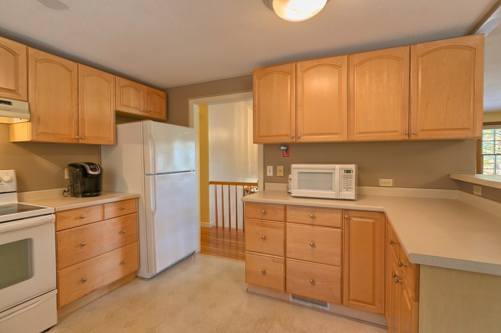 597 Old Dunstable Road Groton, MA 01450 - Photo 10 of 21 a kitchen with white cabinets and refrigerator