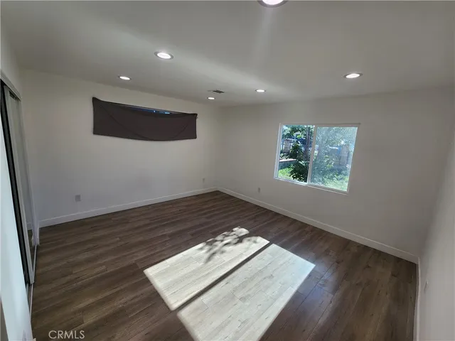 an empty room with wooden floor and window