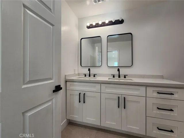 a bathroom with a double vanity sink and a mirror